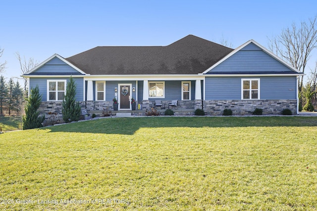 craftsman-style home with stone siding, a porch, and a front yard