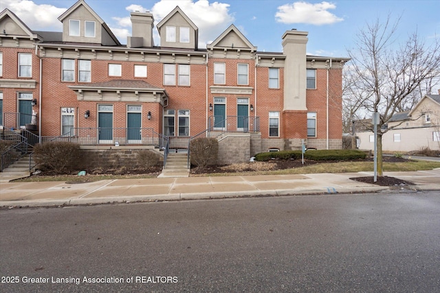 multi unit property with brick siding and a chimney