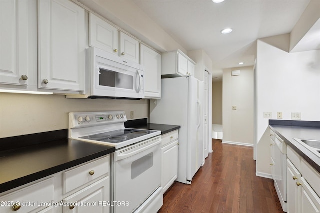 kitchen featuring dark wood-style floors, white appliances, dark countertops, and white cabinets