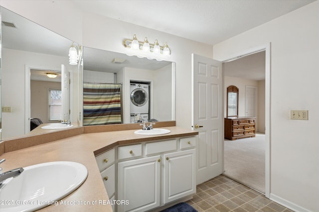 full bathroom with visible vents, double vanity, a sink, and stacked washer and clothes dryer