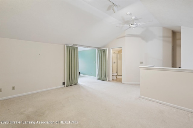 bonus room featuring lofted ceiling, baseboards, a ceiling fan, and light colored carpet