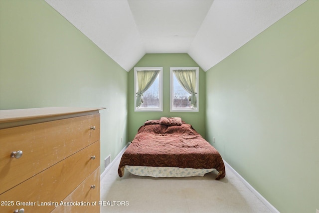 carpeted bedroom featuring baseboards, visible vents, and vaulted ceiling