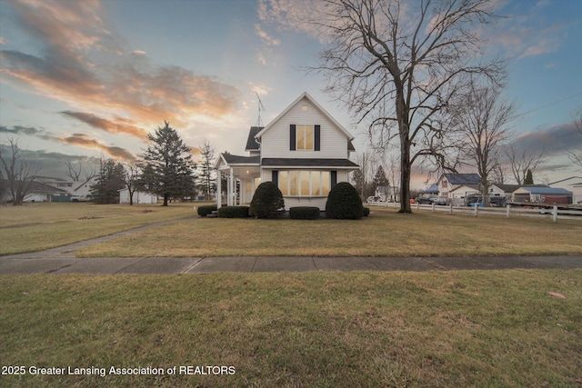 view of front of property with fence and a lawn