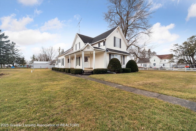 view of side of property with covered porch and a yard