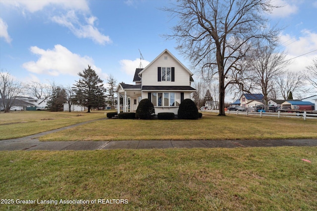 view of front of house featuring fence and a front lawn