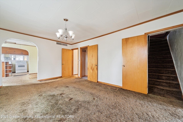 spare room with carpet floors, crown molding, visible vents, baseboards, and stairs