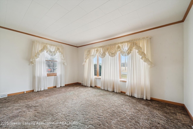 unfurnished room with carpet, visible vents, baseboards, and crown molding