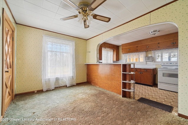 kitchen featuring wallpapered walls, white electric range oven, arched walkways, brown cabinets, and crown molding