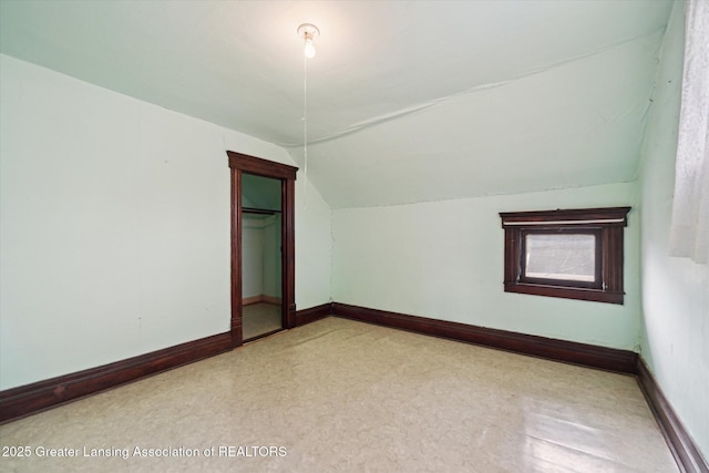 additional living space featuring vaulted ceiling and baseboards