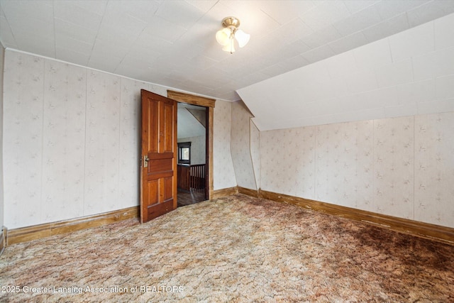 bonus room with carpet floors, lofted ceiling, baseboards, and wallpapered walls