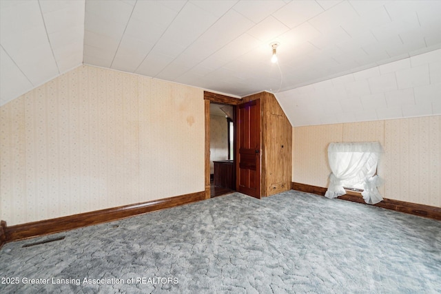 bonus room with vaulted ceiling, baseboards, carpet flooring, and wallpapered walls