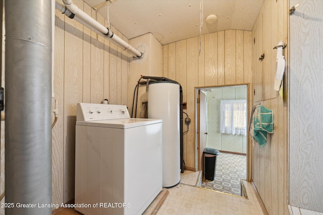 laundry room with laundry area, washer / clothes dryer, light floors, and wood walls