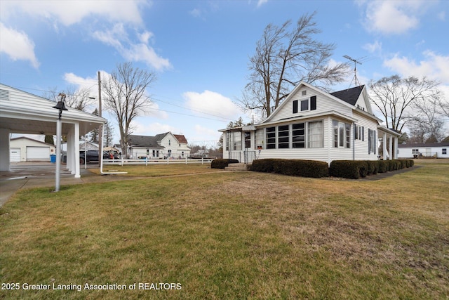 view of property exterior with a yard, an outdoor structure, and fence