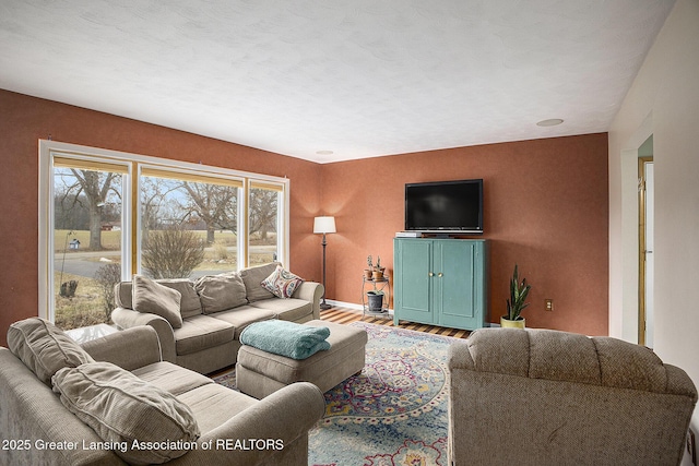 living area with baseboards and wood finished floors