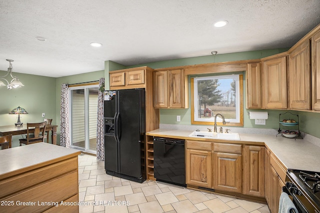 kitchen with decorative light fixtures, light countertops, a sink, a textured ceiling, and black appliances