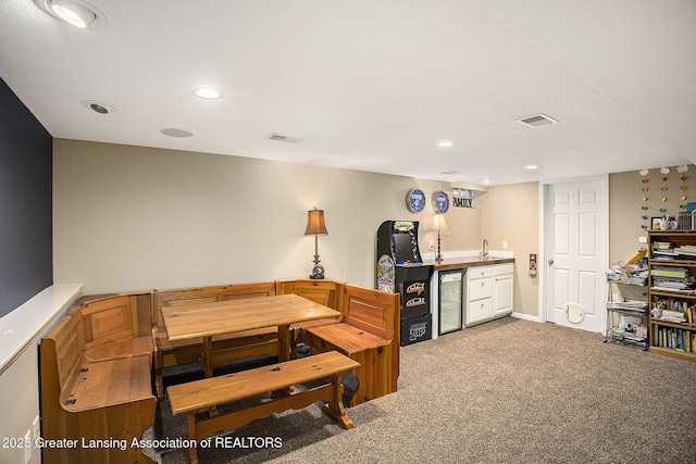 dining space with carpet floors, wine cooler, wet bar, and visible vents