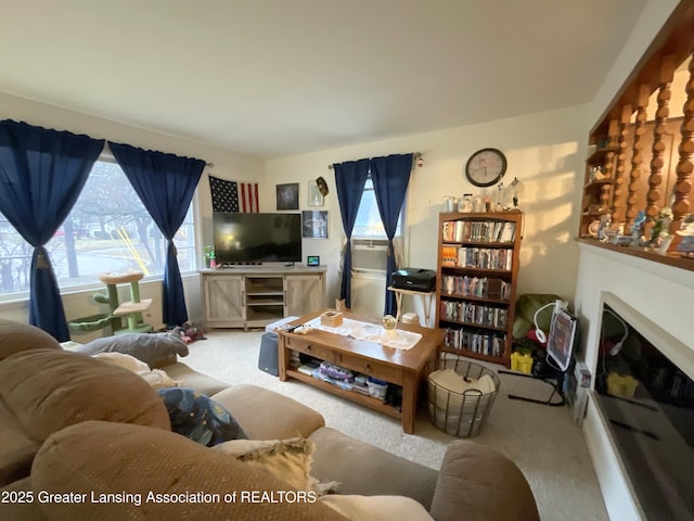 living room with a wealth of natural light, a fireplace, and carpet