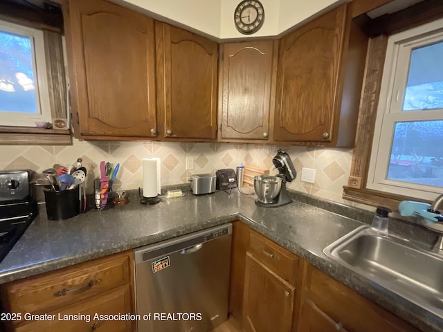 kitchen with a wealth of natural light, brown cabinetry, dishwasher, backsplash, and a sink