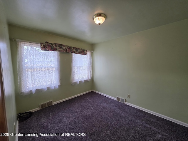 unfurnished room with carpet flooring, visible vents, and baseboards