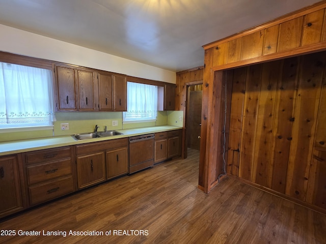 kitchen with dishwashing machine, dark wood-style flooring, light countertops, and a sink