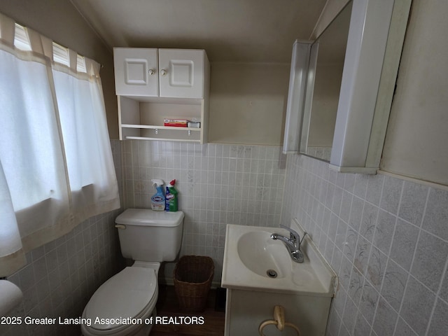 bathroom with tile walls, toilet, and vanity