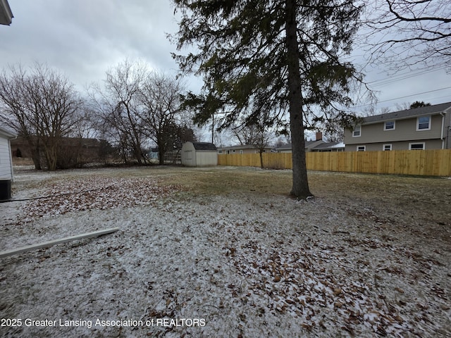 view of yard with an outbuilding, fence, and a shed