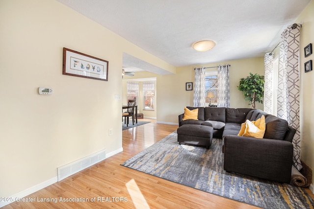 living area with visible vents, baseboards, and wood finished floors