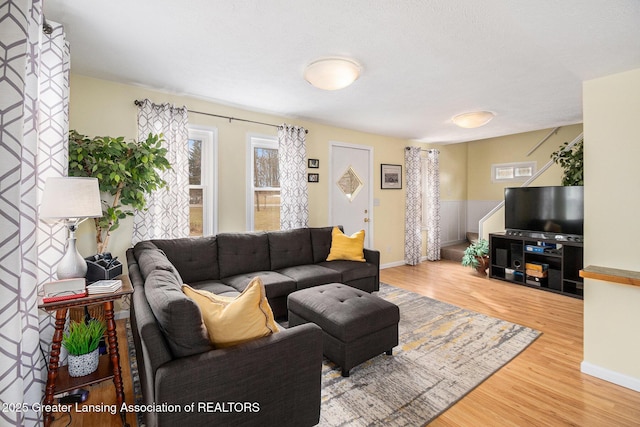 living area with baseboards and wood finished floors