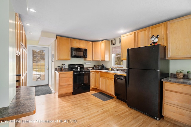 kitchen with light wood-style flooring, a sink, a healthy amount of sunlight, light brown cabinetry, and black appliances