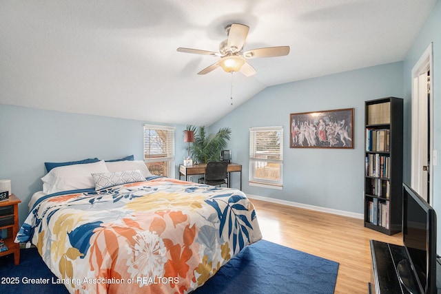 bedroom with lofted ceiling, ceiling fan, wood finished floors, and baseboards