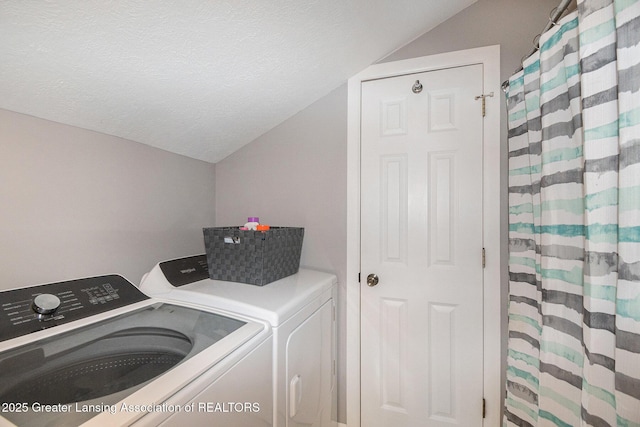 washroom featuring laundry area, a textured ceiling, and separate washer and dryer