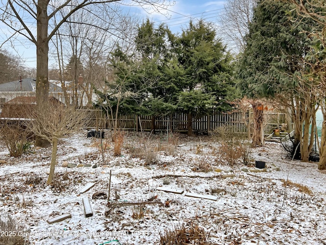 yard layered in snow featuring fence