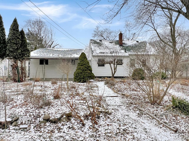 snow covered house with a chimney