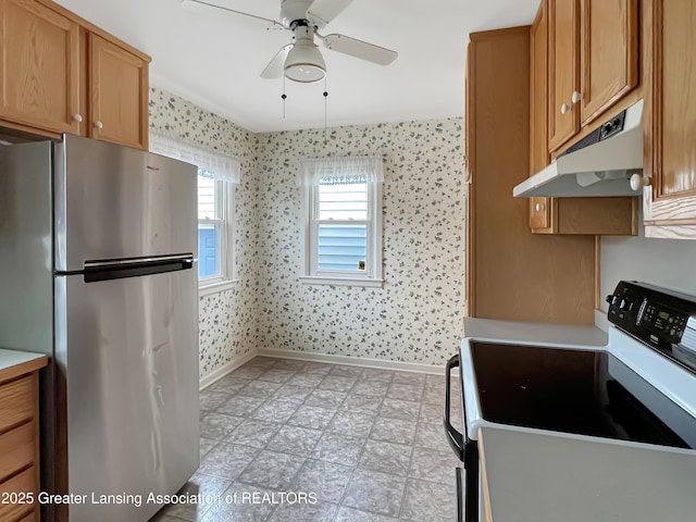 kitchen featuring wallpapered walls, white electric stove, light floors, freestanding refrigerator, and under cabinet range hood