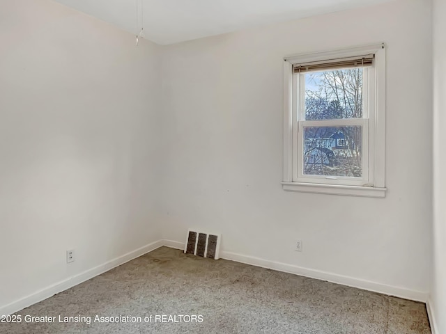 unfurnished room with baseboards and visible vents