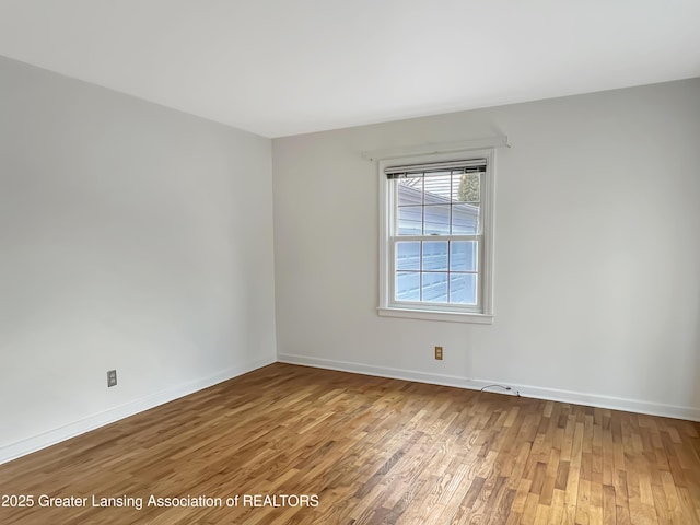 empty room with wood finished floors and baseboards