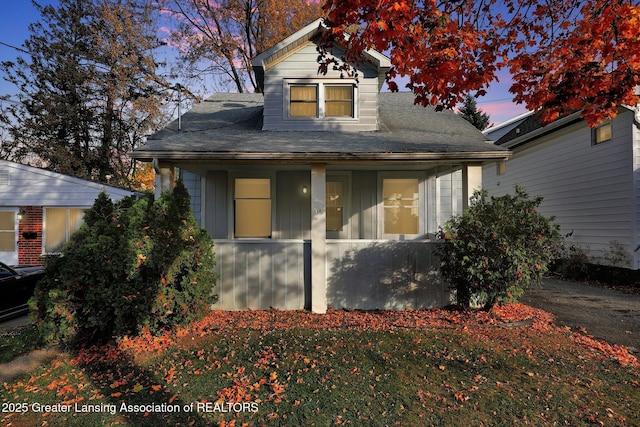 view of front of house with roof with shingles and covered porch