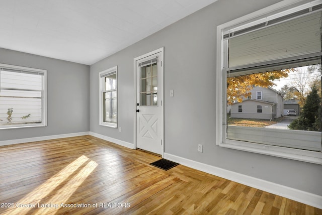 entryway with visible vents, wood finished floors, and baseboards