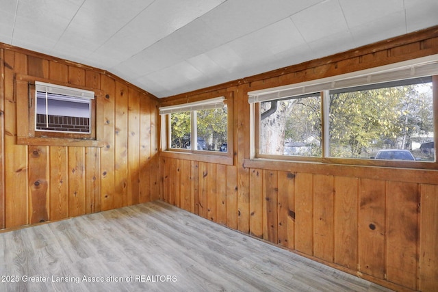 interior space featuring wood finished floors, wood walls, and vaulted ceiling