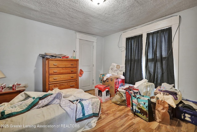 bedroom featuring a textured ceiling and wood finished floors