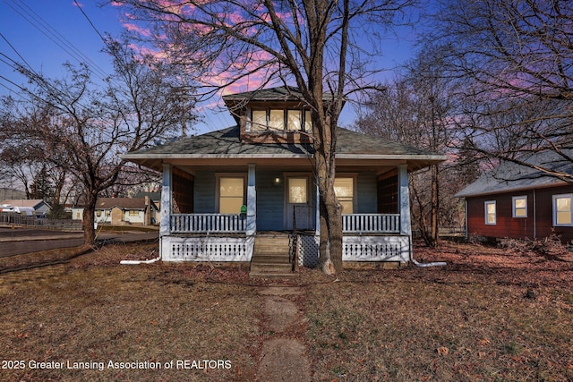 bungalow-style home with a porch and a shingled roof