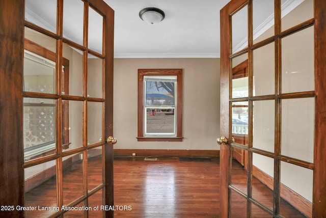 spare room with ornamental molding, french doors, baseboards, and wood finished floors