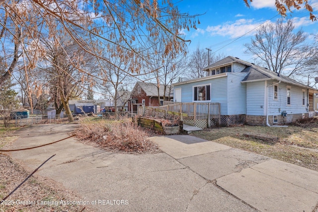 view of front of home with a shingled roof and fence