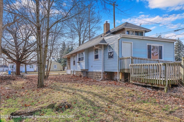 view of side of property with a chimney and a wooden deck