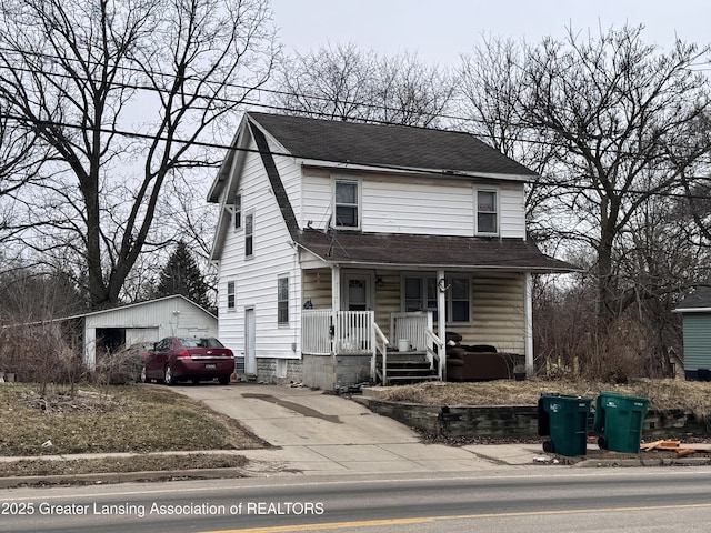 view of front of home featuring an outbuilding, covered porch, roof with shingles, and driveway