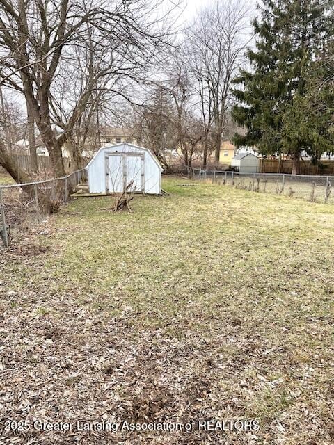 view of yard featuring an outbuilding, a fenced backyard, and a shed