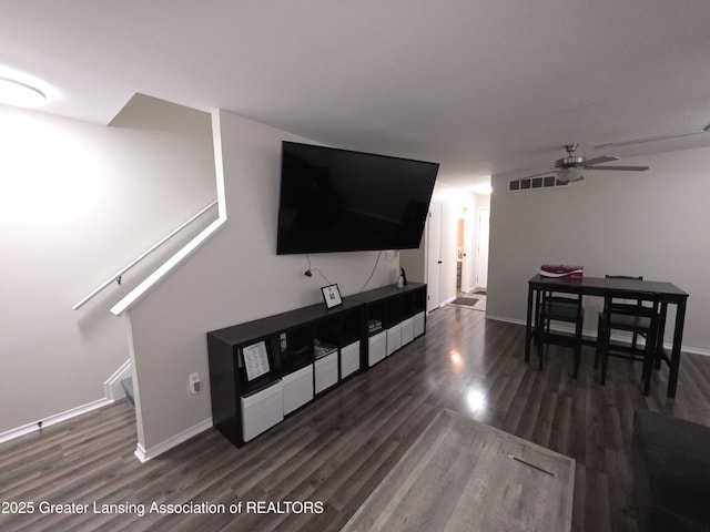 living area with baseboards, wood finished floors, visible vents, and a ceiling fan