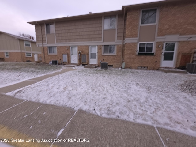 back of property with central AC unit, crawl space, and brick siding