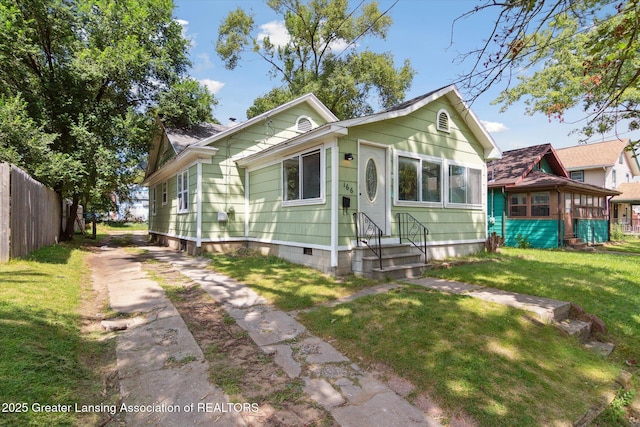 view of front of property with crawl space, a front lawn, and fence