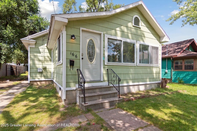 bungalow-style home featuring a front lawn and entry steps